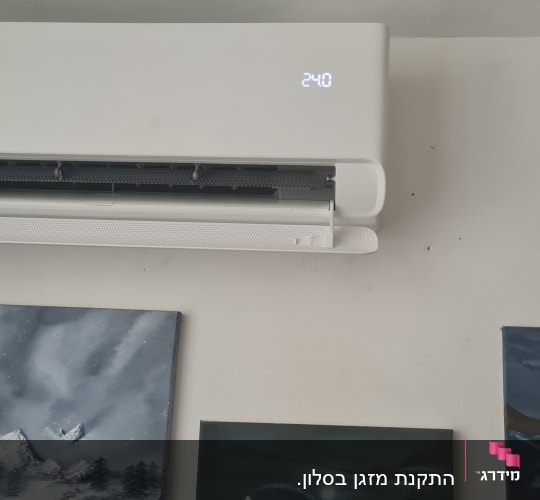 מזגן קיר לבן עם תצוגת טמפרטורה דולקת